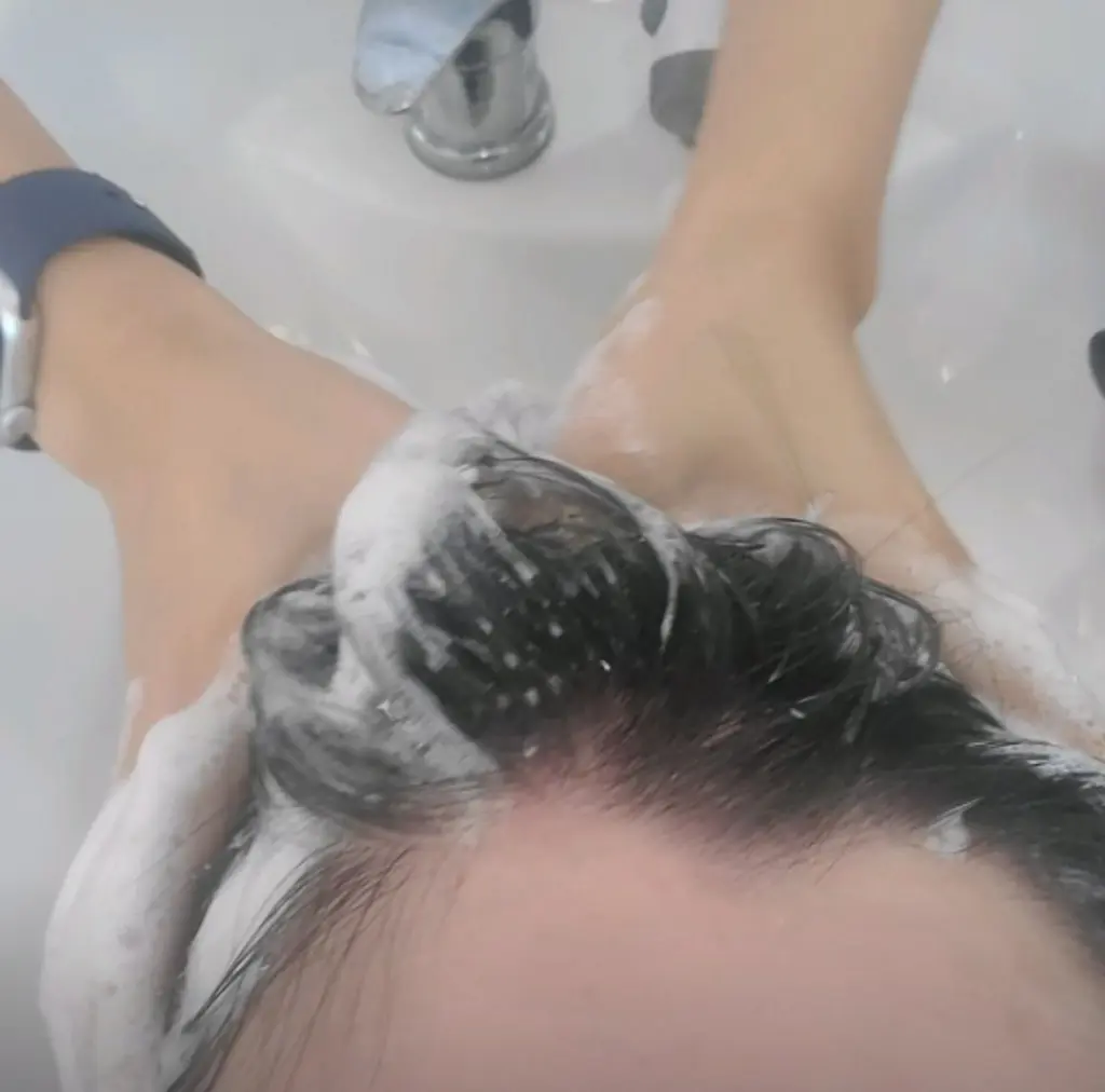 샤워 후 배수구에 쌓인 머리카락을 보며 탈모에 대한 불안감을 느끼는 3040 남성의 고민을 상징